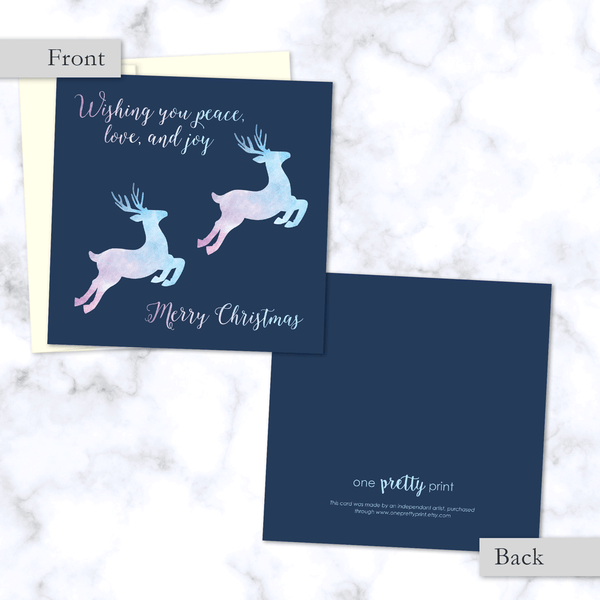 Leaping Reindeer Square Folded Christmas Card. Front and Back View. With Watercolor Textured Reindeer in Pink and Blue - Envelope Included